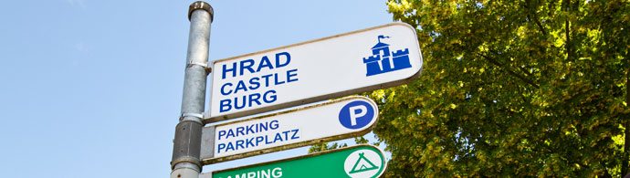 Placas indicando o castelo e o estacionamento em Karlštejn