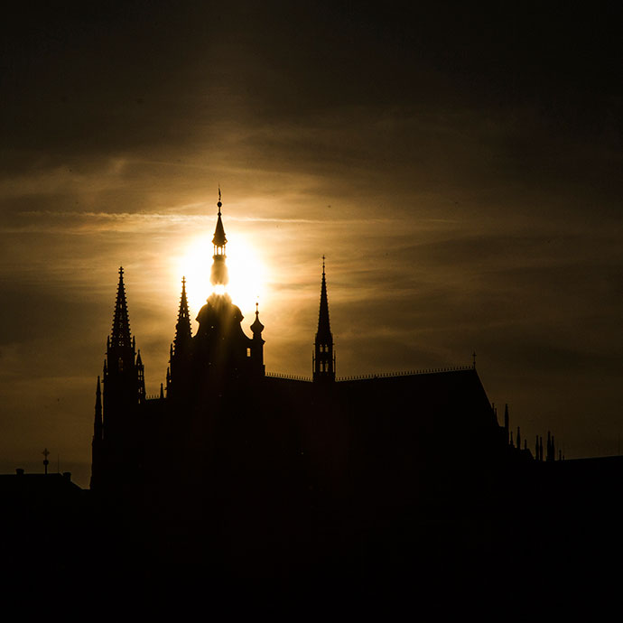 Praga: sol passando atrás da Catedral de São Vito, no solstício de verão