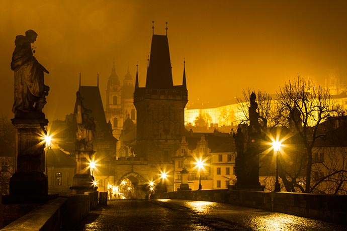 Ponte Carlos, em Praga: torres da Malá Strana à noite, com neblina