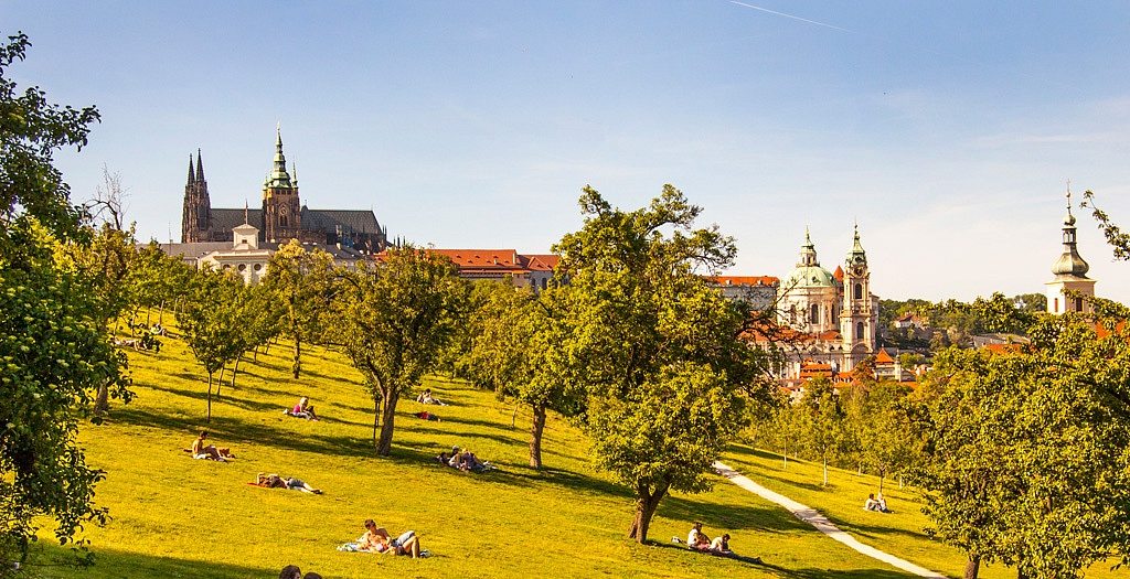 Tchecos jogados ao sol no Parque Petřín, ao lado do Castelo de Praga
