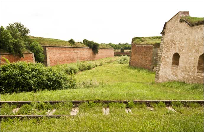 As muralhas do forte e os trilhos de trem em direção aos campos de concentração do Leste, em Terezín